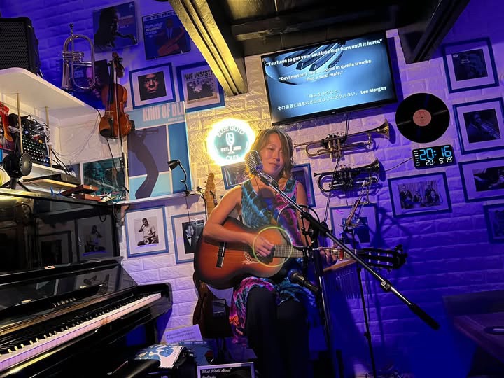 Cazy singing live with a classical guitar